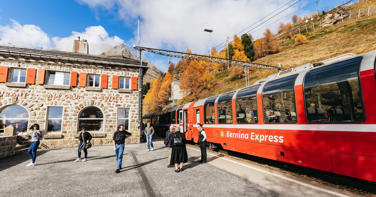The red Bernina Express panoramic train waiting at a mountain station on the Bernina line